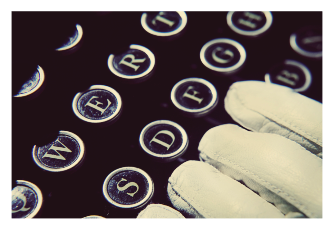 In Her Hands fine art photograph by LiAns JadAn featuring white-gloved hands resting over the keys of a vintage typewriter
