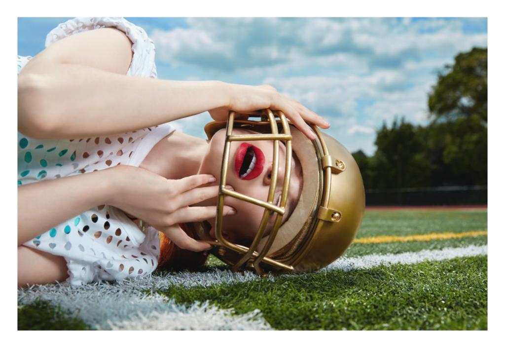Red Zone fine art photograph by LiAns JadAn featuring a fashion portrait with a gold football helmet on a football field